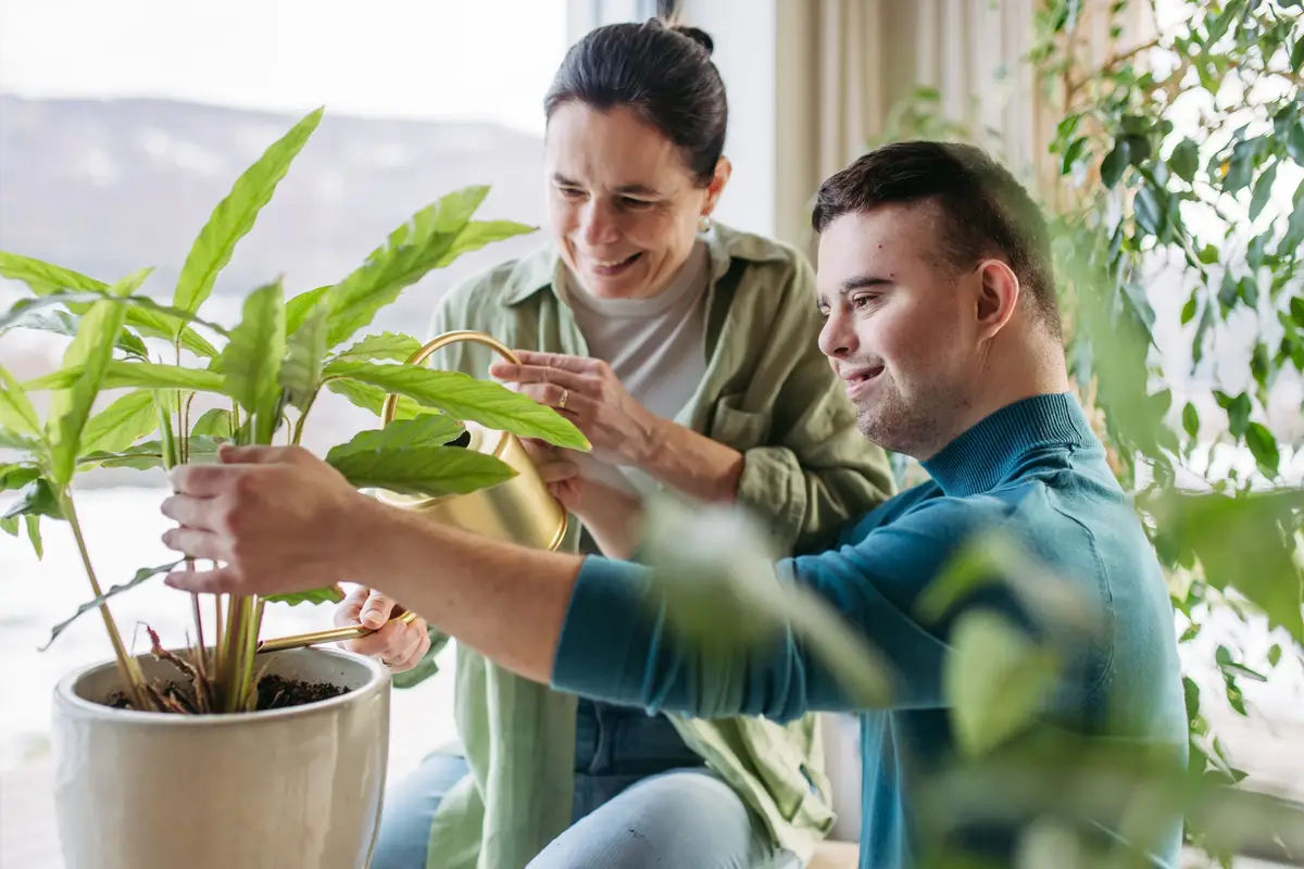 An image of a young man and his mother planting was captured by Your Best Life Independent Living.